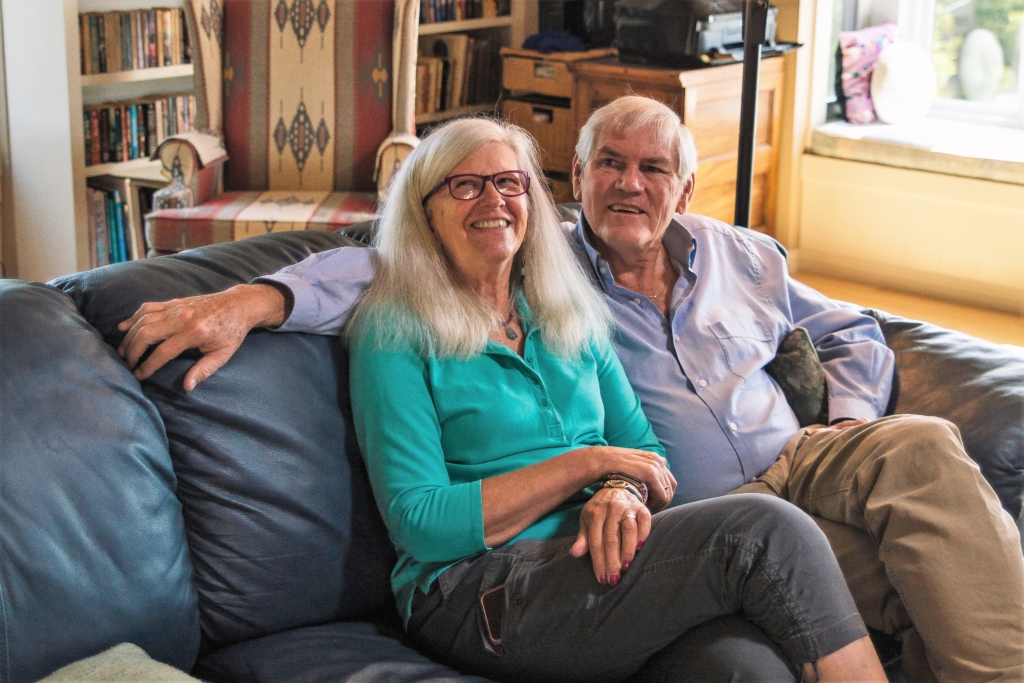 Couple, in their 60s sitting on their sofa together