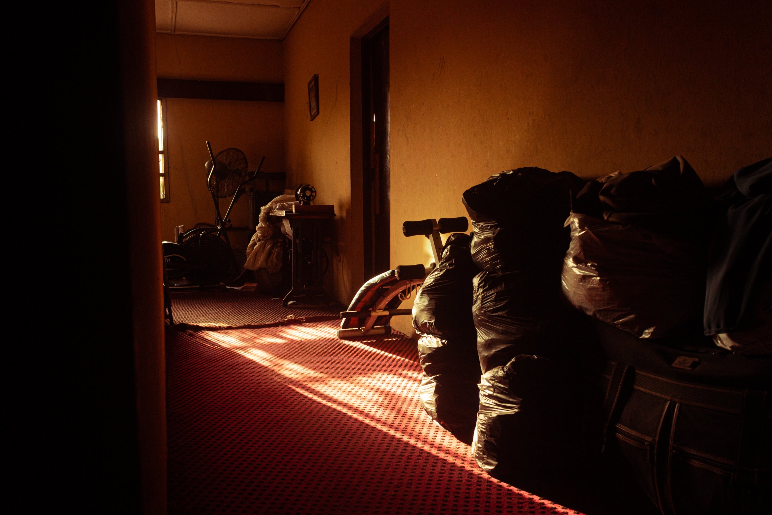 Large plastic bags lined up in a room with red carpet.