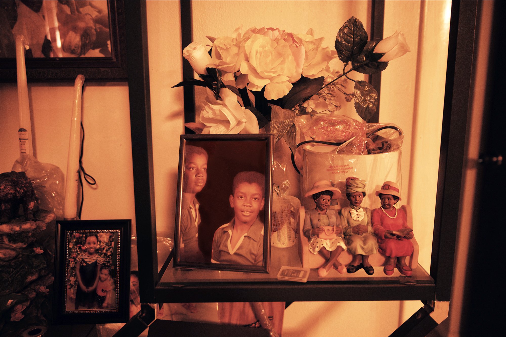 A book shelf with family photos and various decorations.