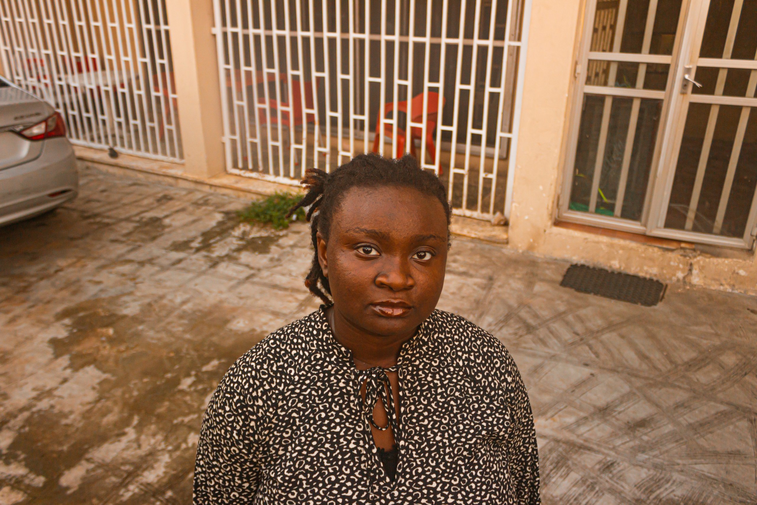 Ife standing outside in front of her house.