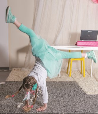 young girl doing gymnastics while another girl watches