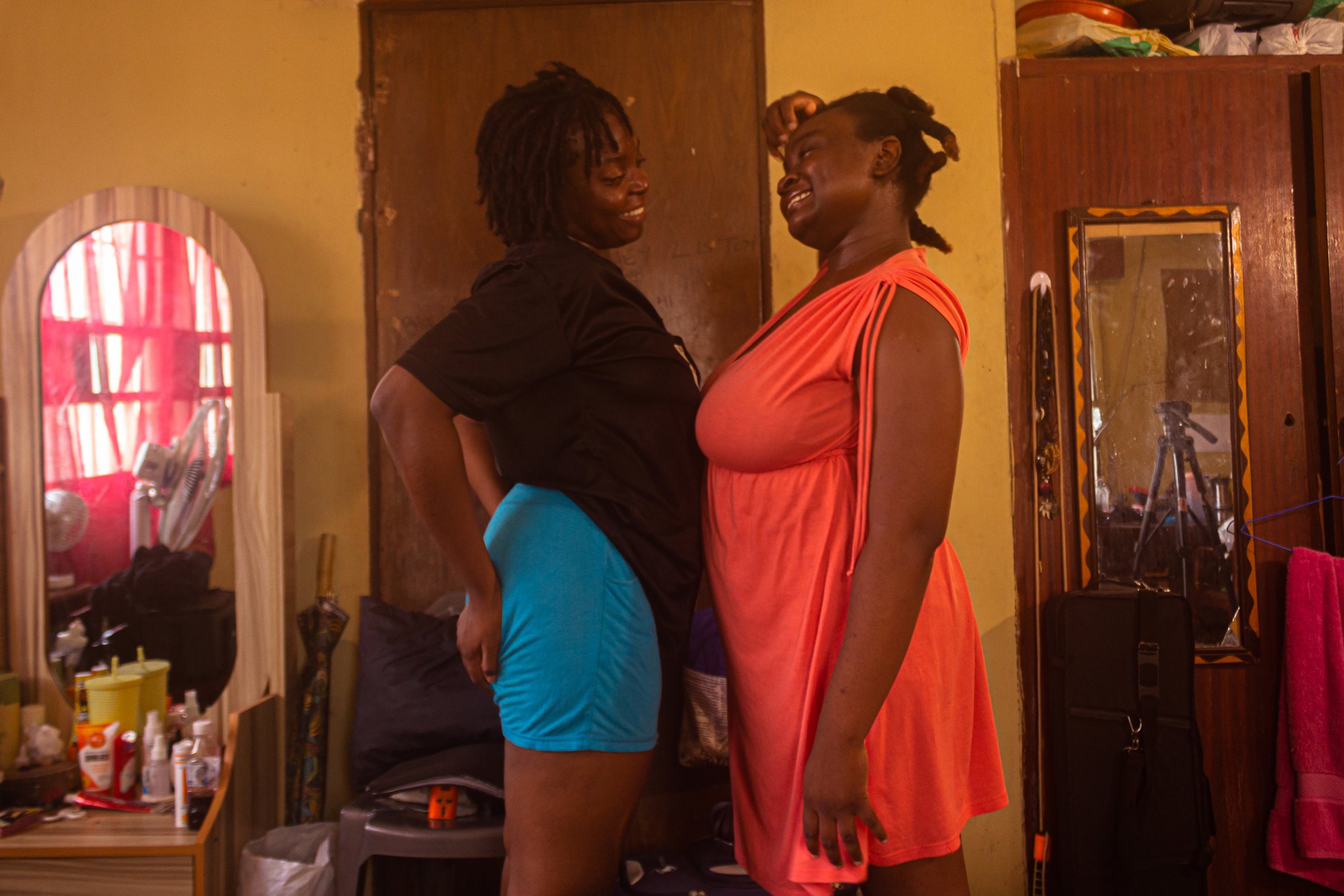 Ife and her sister standing opposite of each other smiling.