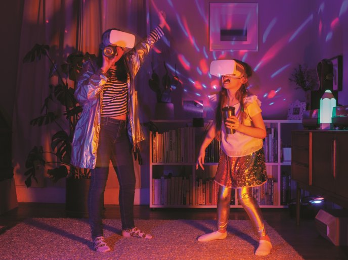 two girls dancing with VR headsets and disco lights in the background