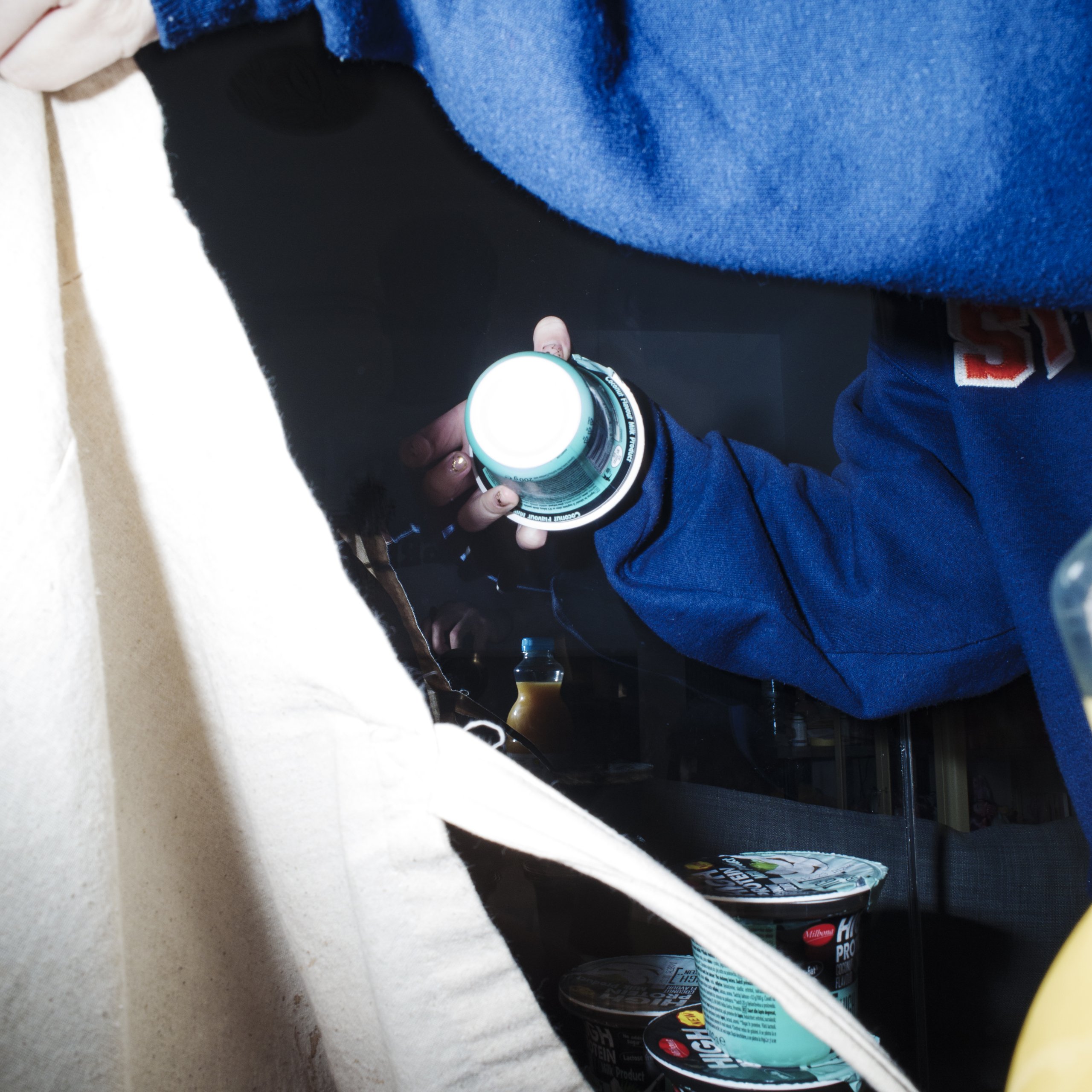 Toma's girlfriend unpacking groceries from a tote bag.