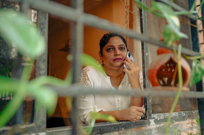 Lady looking out the window on the phone to someone