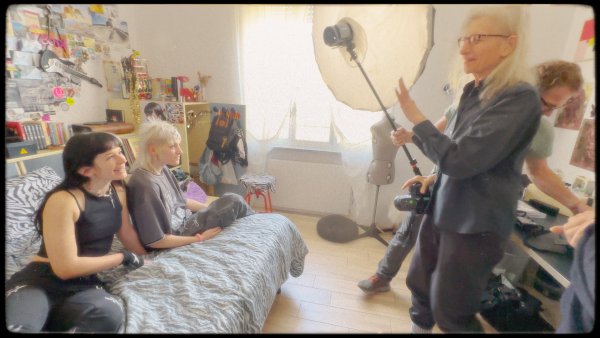 Annie and her crew setting up the equipment in Silvias room while she and her friend sits on the bed.