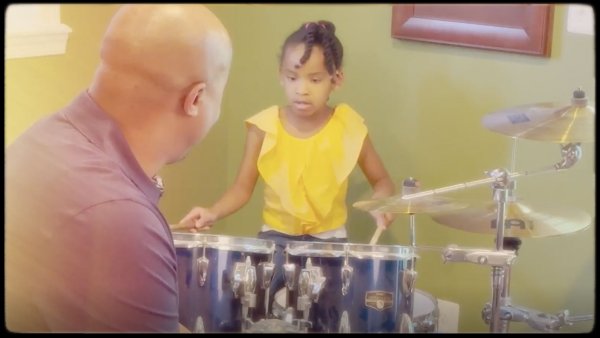 Michael watching his youngest daughter playing the drums.