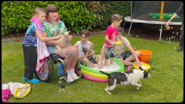 Nina, her four sons and three dogs playing in the garden.