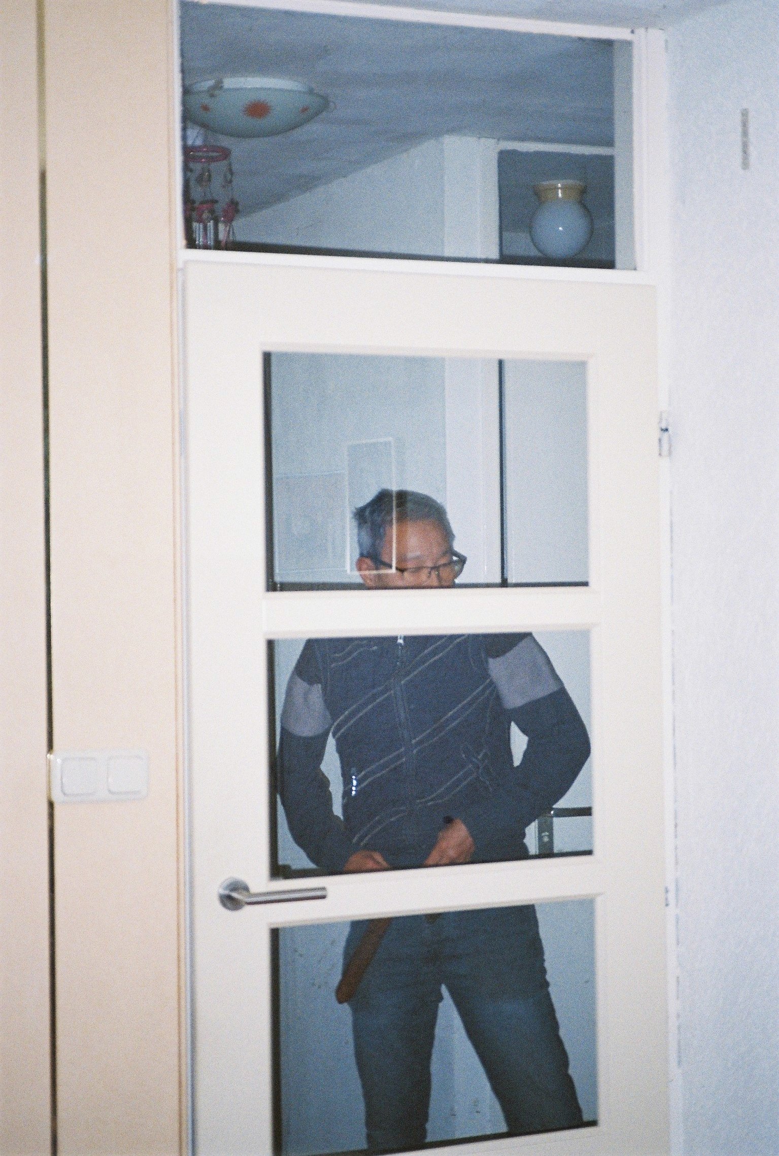 Trams father standing behind a glass door.